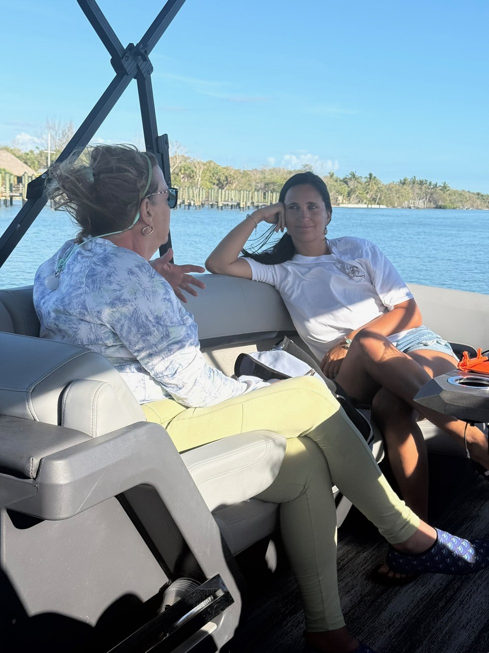 First Mate Cristina chatting with a guest aboard a Sand Dollar pontoon in the Ten Thousand Islands