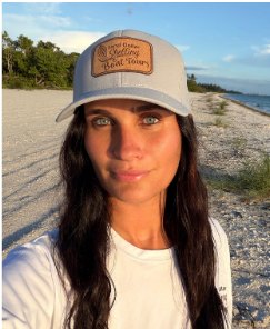 First Mate Cristina in a Sand Dollar Shelling & Boat Tours cap on a shell-covered beach