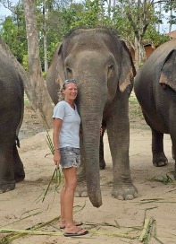 Captain Lauren Malinowski standing between two elephants while traveling