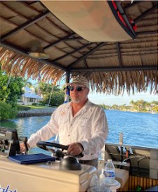 Captain Paul O'Neill at the tiki boat helm on Naples Bay