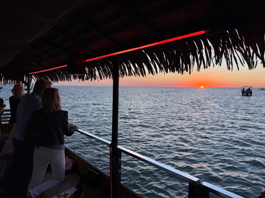 A fiery red-orange Gulf sunset behind the Sand Dollar tiki boat near Marco Island, Florida