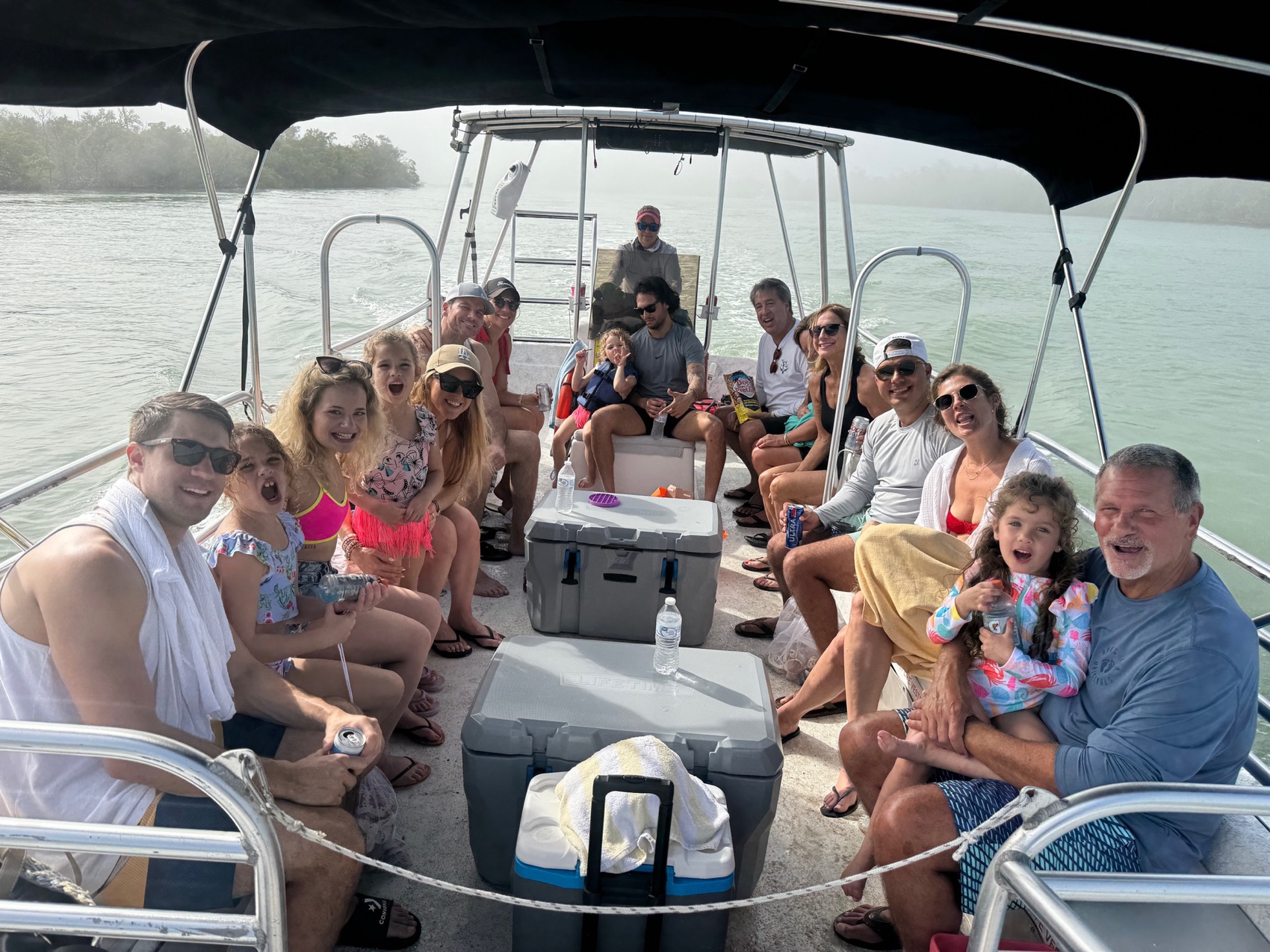 Guests aboard a private Sand Dollar charter boat under the shade of the bimini on calm water near Naples, Florida