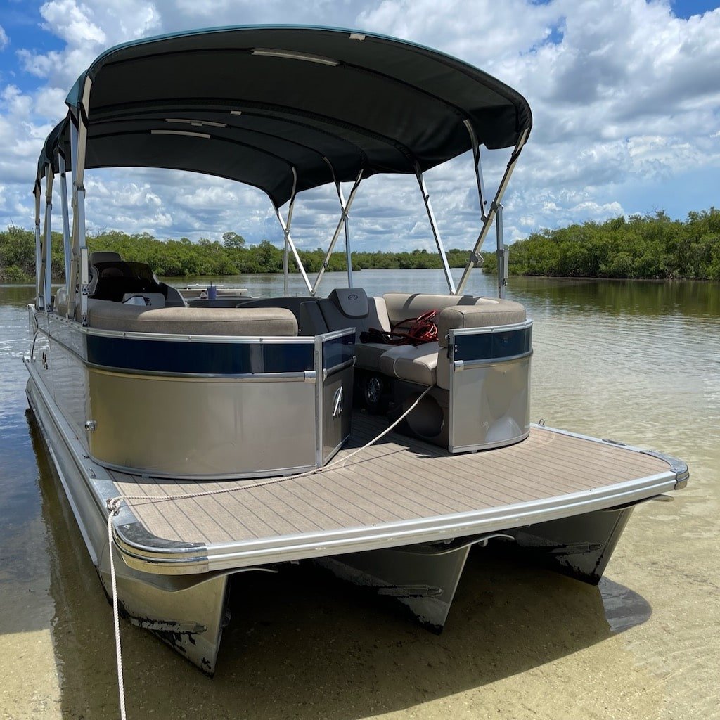 A Sand Dollar tritoon boat anchored in the turquoise shallows of the Ten Thousand Islands near Marco Island