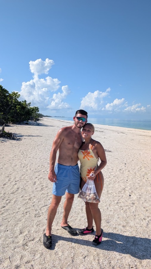 A couple ready for a shelling tour with bags and hats on a beach near Naples, Florida